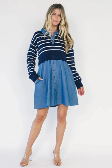 Model wearing a navy and ivory striped sweater dress with a collared neckline, functional button-front detail, long sleeves, and an elastic waist.