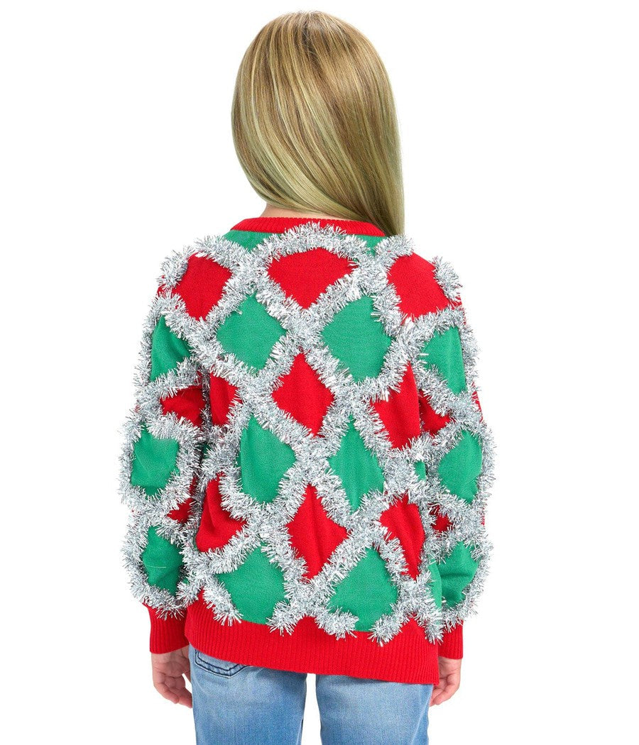 Girl wearing a festive sweater with red and green decorations on a white background