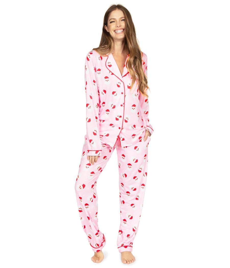 Woman wearing a pink pajama set with cherry pattern on a white background